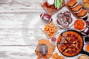 Superbowl or football theme food side border on a white wood background photo