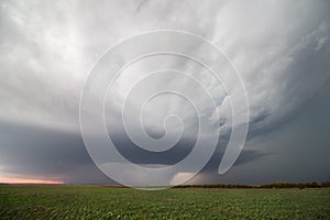 A supercell thunderstorm hovers over farmland in Kansas.