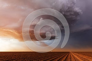 Supercell thunderstorm with inflow dust at sunset