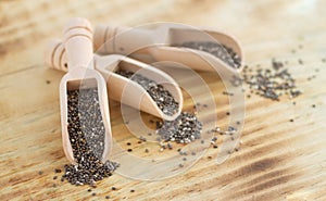 Superfood chia seeds in wooden scoops close-up