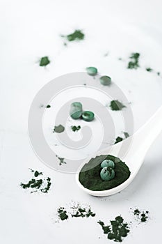 Superfood concept ground green spirulina algae powder, pills tablets