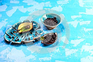 Superfoods antioxidant of indian mapuche. Bowl of fresh maqui berry on blue background, top view Authentic lifestyle image