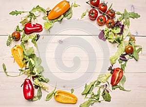 Superfoods and health or detox diet food concept various vegetables and herbs lined frame on white wooden table, cherry tomatoes