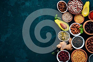 Superfoods Healthy food. Nuts, berries, fruits, and legumes. On a black stone background.