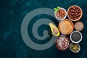 Superfoods Healthy food. Nuts, berries, fruits, and legumes. On a black stone background.