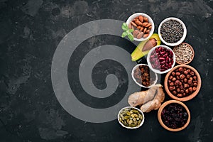 Superfoods Healthy food. Nuts, berries, fruits, and legumes. On a black stone background.