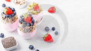 Superfoods layered pudding with granola, blueberry and strawberry in glasses. Yogurt with chia seeds, berries, kiwi and muesli for