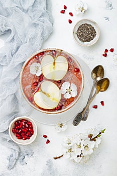 Superfoods smoothie bowl with chia seeds, pomegranate, sliced apples and honey. Overhead, flat lay. Rosh Hashana traditional food