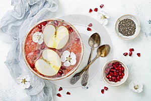 Superfoods smoothie bowl with chia seeds, pomegranate, sliced apples and honey. Overhead, flat lay. Rosh Hashana traditional food