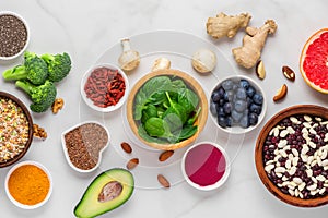 Superfoods on white marble table. vegetables, acai, turmeric, fruits, berries, nuts and seeds. Healthy food