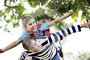 Superhero boy flying on the back of his dad