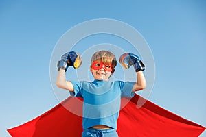 Superhero child against summer blue sky