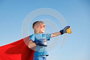 Superhero child against summer blue sky