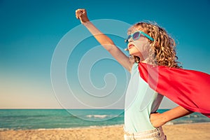 Superhero child on the beach. Summer vacation concept