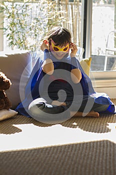 Superhero child laughing while dressing up for fun successful lockdown