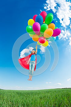 Superhero child playing outdoors in spring field