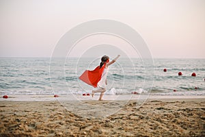 Superhero kid against blue sky background. Joy and childhood concept