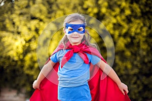 Superhero kid against green background outdoor. Childhood, success and and power concept
