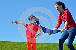 Superhero mother show her daughter how to be a superhero