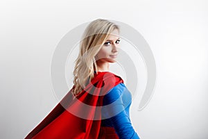 Superhero Woman looking off into the distance at right. Young and beautiful blonde in image of superheroine, back