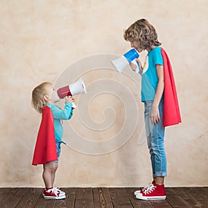 Superheroes children speaking by loudspeaker