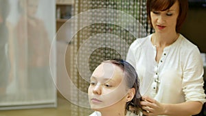 Superimposition of hair gel to wet clean the client`s hair in beauty salon