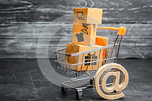 Supermarket cart with boxes, merchandise: the concept of buying and selling goods and services, internet commerce, online shopping