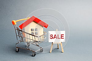Supermarket cart with houses and a Sale Poster. The concept of selling a home, real estate services or buying from the owner.
