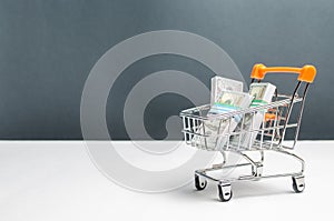 Supermarket cart with packs of dollars. The concept of microcredit and payday loans. Advertising financial services. Trap