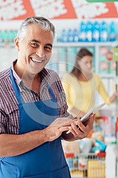 Supermarket clerk using a tablet photo