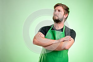 Supermarket employee with green apronand black t-shirt confident hero-shot