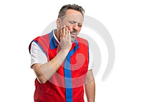 Supermarket employee touching cheek as toothache concept