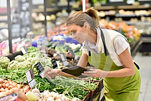 Supermarket employee in vegetable section