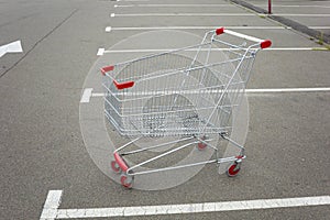 Supermarket parking lot with a large metal shopping cart on wheels