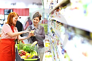 Supermarket salesperson advises a customer - fresh food sales photo