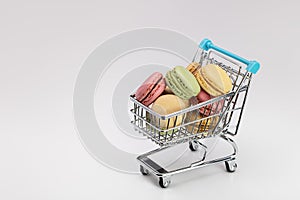 Supermarket shopping cart with colorful macaroons.