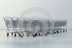 Supermarket shopping carts on light background. Online shopping, sales, Black Friday sale concept. A lot of shopping mall trolleys