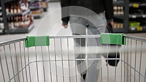 Supermarket shopping trolley motion. Stylish woman in the supermarket with a grocery cart