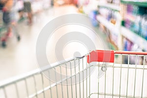 Supermarket store blurred background with close up shopping cart