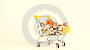 Supermarket trolley filled with medical capsules on a white background