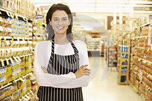 Supermarket Worker Standing In Grocery Aisle photo