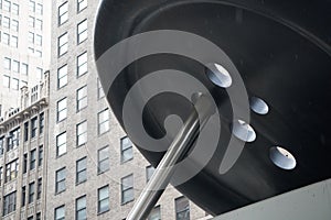 Supersized button with needle threading hole with skyscraper apartments in background