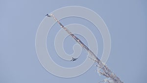 Supersonic planes in the blue sky perform aerobatics. The plane releases fireworks.