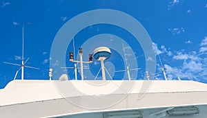 Superstructure of a ship with antennas and a radar against a blue sky