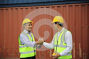 Supervisor checking and control loading Containers box from Cargo at harbor.