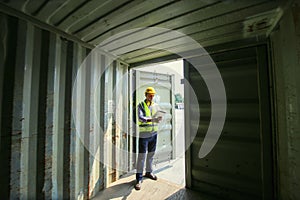 Supervisor checking and control loading Containers box from Cargo at harbor.