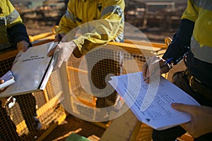 Supervisor checking before sigh of working at height permit JSA risk assessment on site prior to performing high risk work