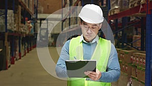 Supervisor doing stocktaking of products at warehouse