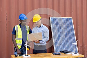 Supervisor and engineering are discussing projects about solar energy and  wind energy systems on laptop