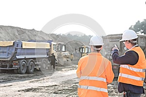 Supervisor explaining plan to colleague at construction site